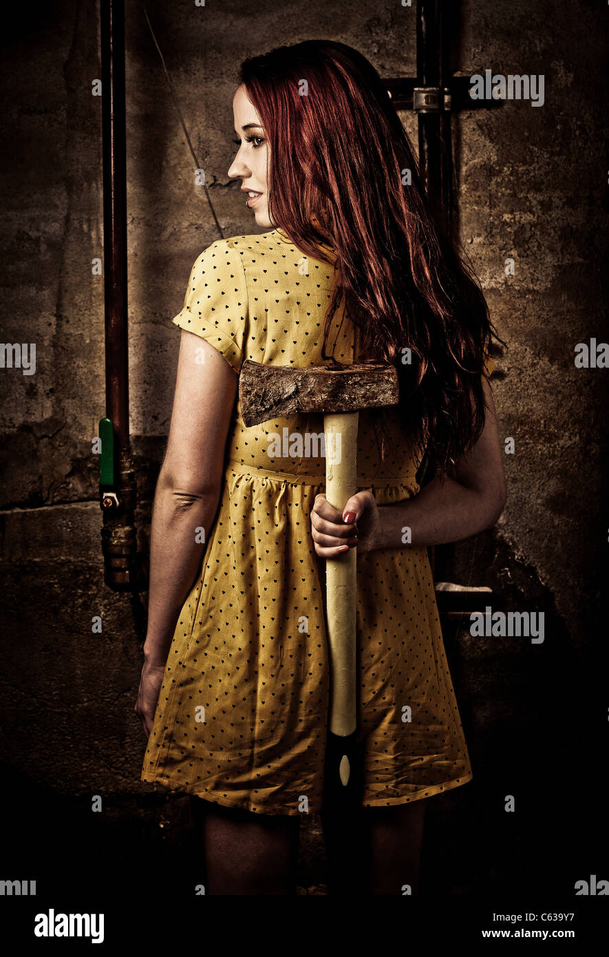 Una giovane donna redhaired con un arrugginito ax Foto Stock