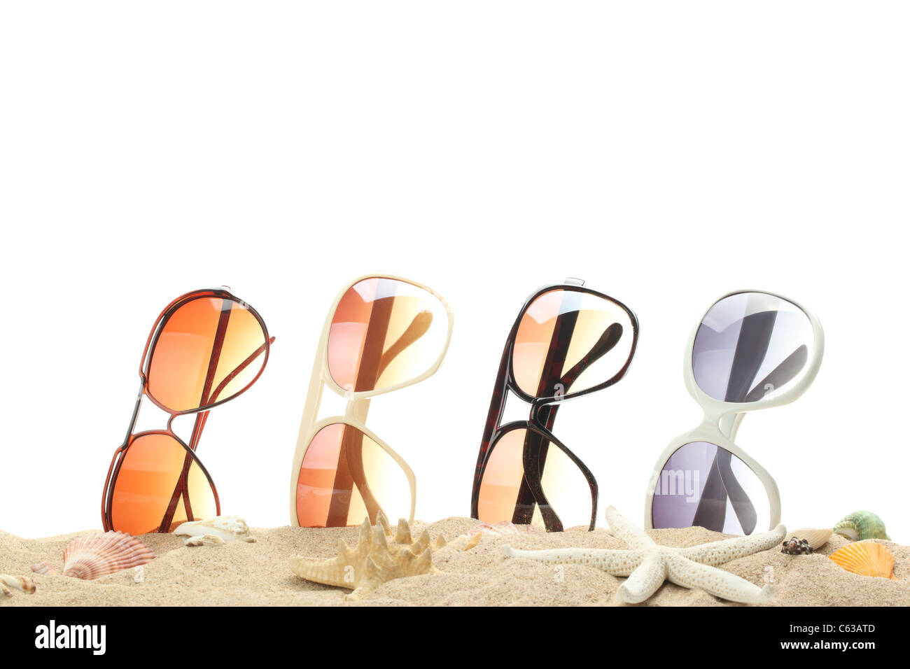 Riga di coloratissimi occhiali da sole sulla sabbia. Foto Stock