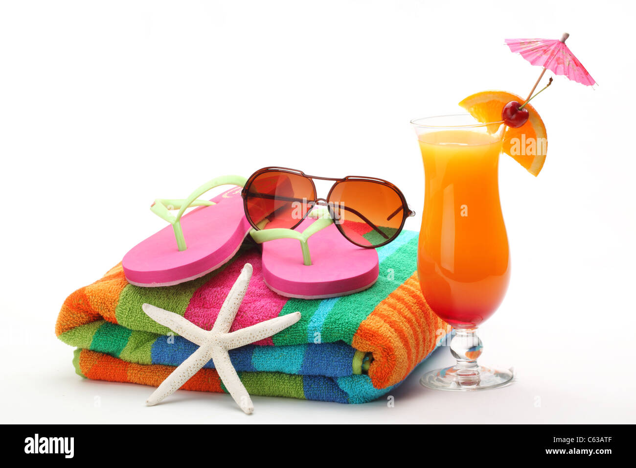 Accessori in spiaggia con il costume da bagno e Tequila Sunrise cocktail su sfondo bianco. Foto Stock
