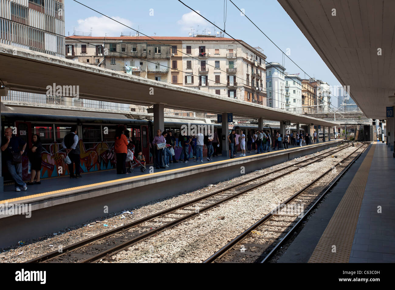 Stazione ferroviaria di Pompei, Italia mostra gli edifici moderni, con l'attesa la folla e i binari della ferrovia in primo piano. Foto Stock