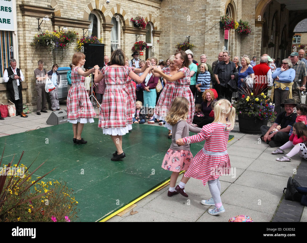 Le giovani ragazze danza con Appalachian intasare i ballerini di 'Step questo modo' esecuzione a Saltburn Folk Festival, North East England, Regno Unito Foto Stock