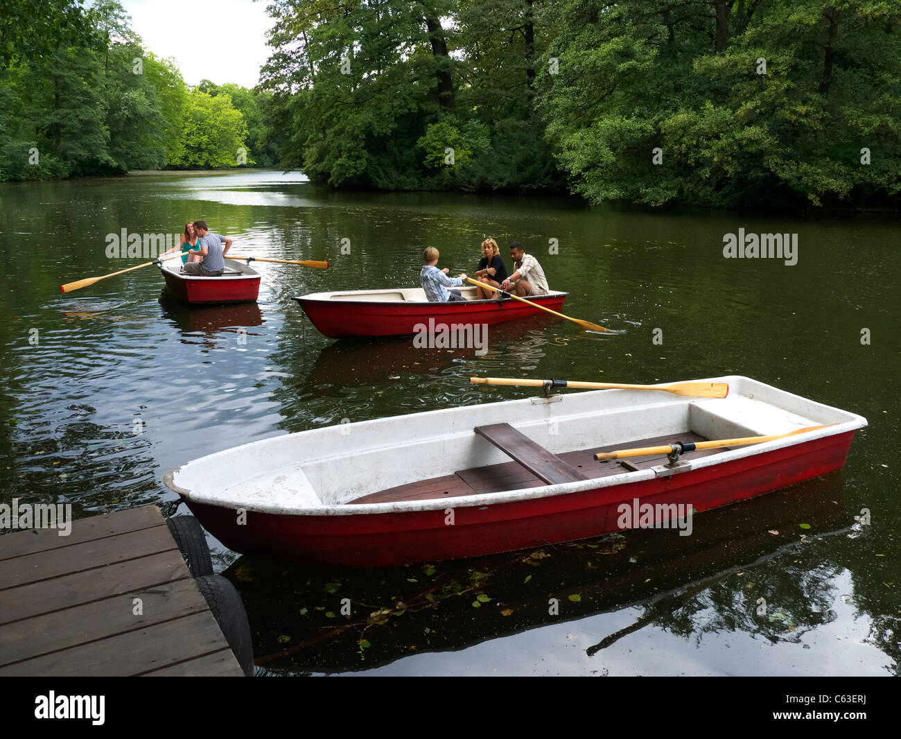 Persone imbarcazioni a remi nel lago al parco Tiergarten di Berlino Germania Foto Stock