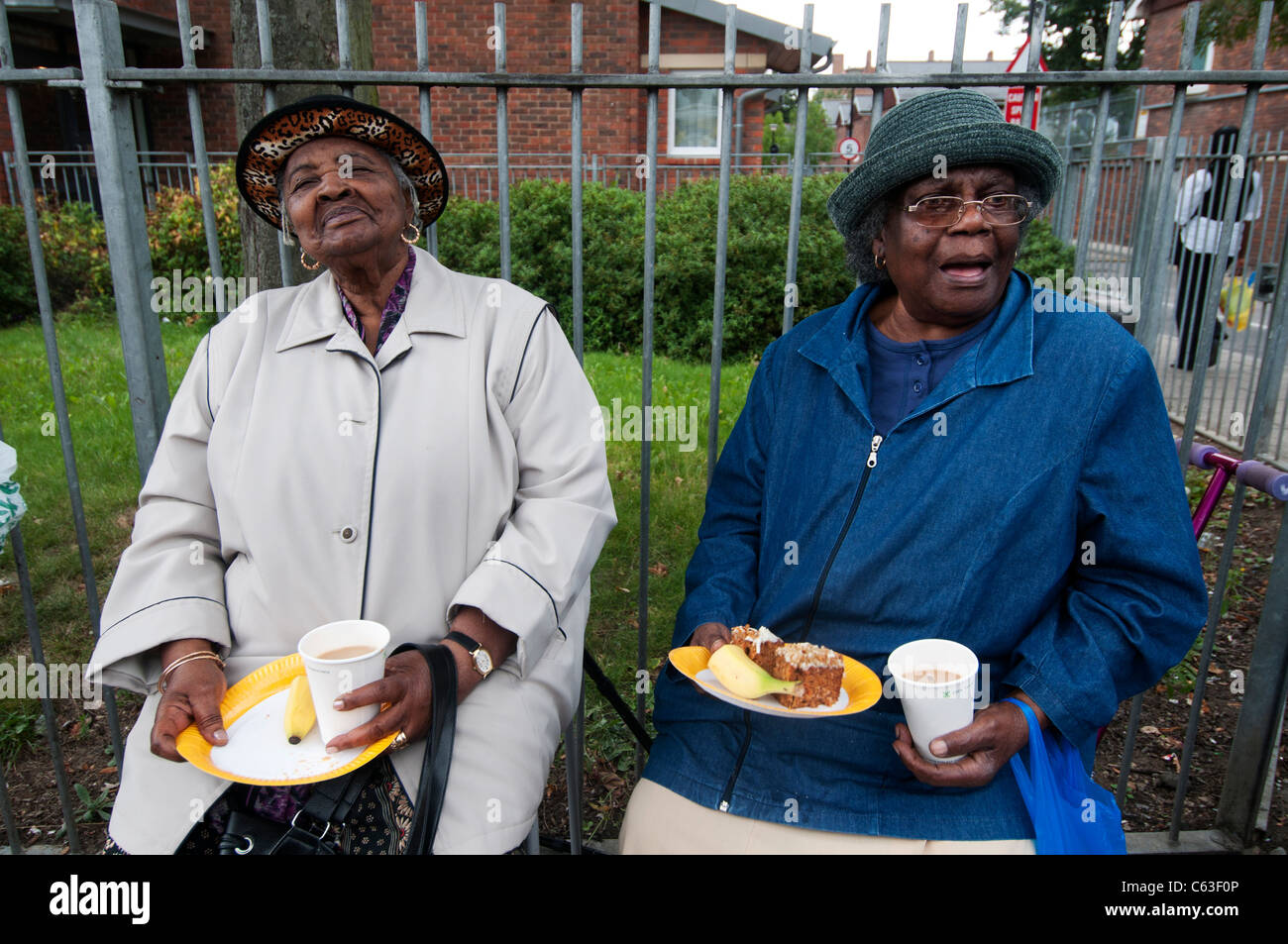 Clarence Road Hackney. Street tea party una settimana dopo i tumulti.due anziani afro-caraibica donne con tè e una fetta di torta Foto Stock