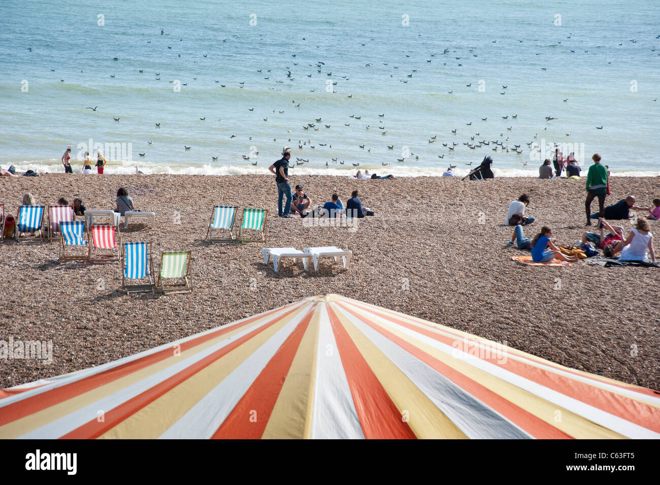 Scena di spiaggia con i vacanzieri in Brighton Foto Stock