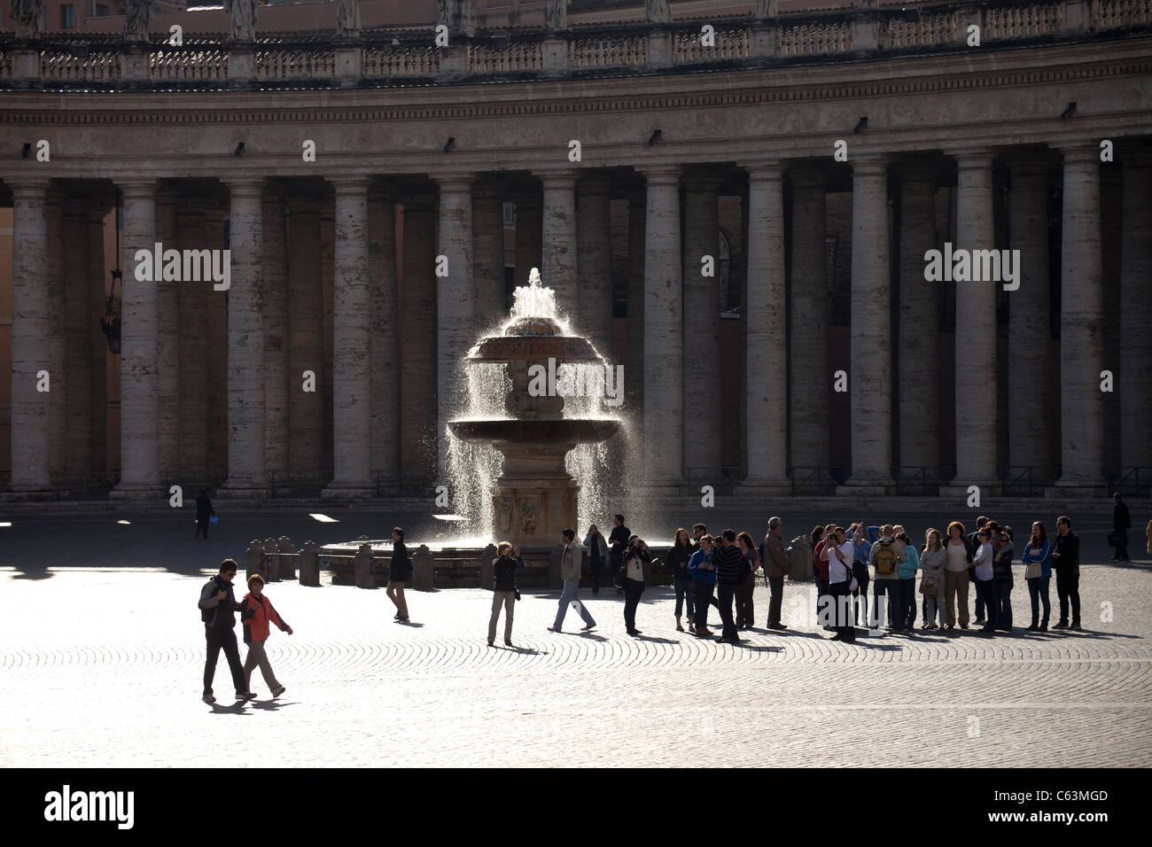 I visitatori di fronte a una fontana in Piazza San Pietro a Roma, Italia, Europa Foto Stock