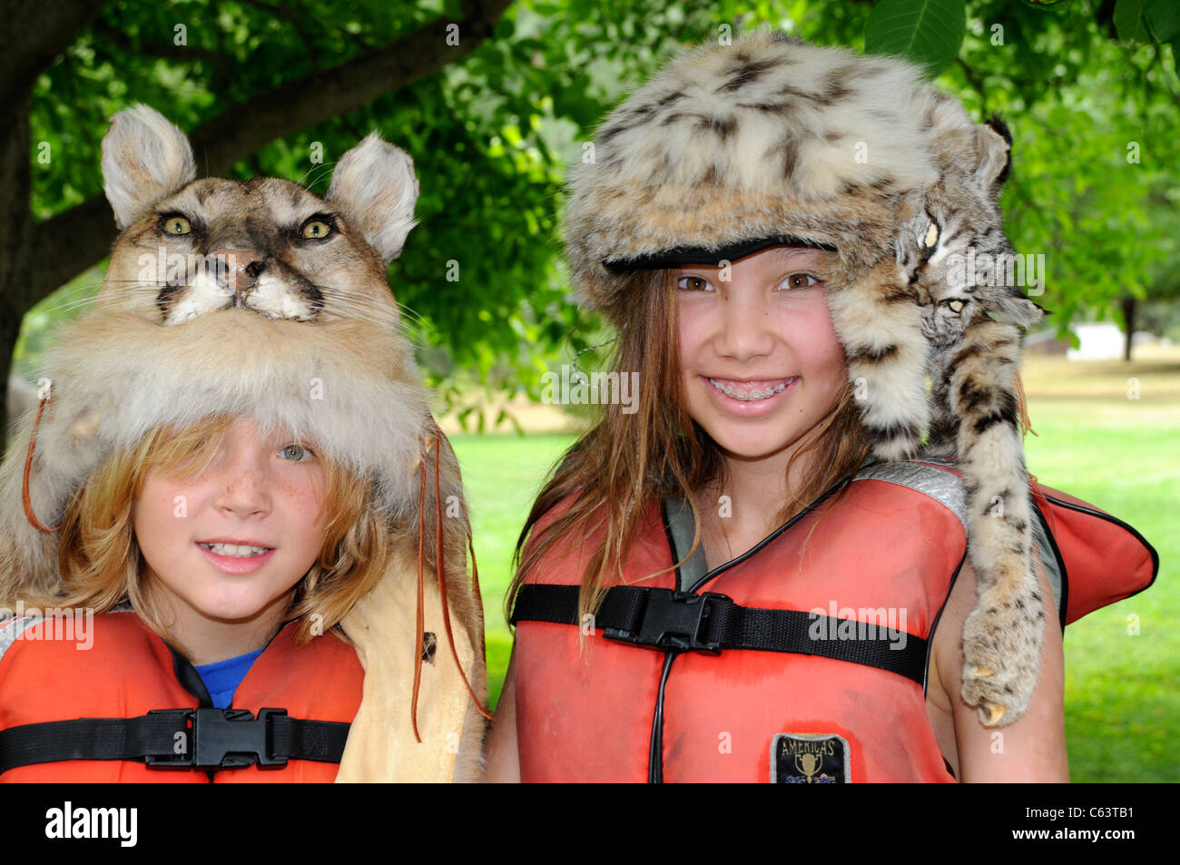 Un ragazzo e una ragazza 8-12 anni di indossare il gatto selvatico cappelli di pelliccia durante Salmon River Rafting Trip in Idaho Foto Stock
