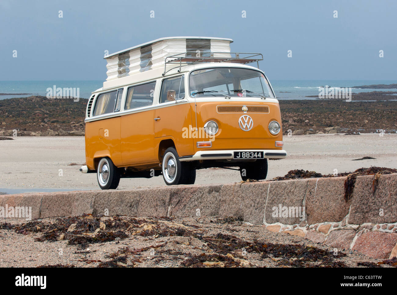 VW Volkswagen bay window Devon camper van classic raffreddato ad aria con propulsori posteriore van pop up tetto spiaggia sollevata arancione bianco Foto Stock