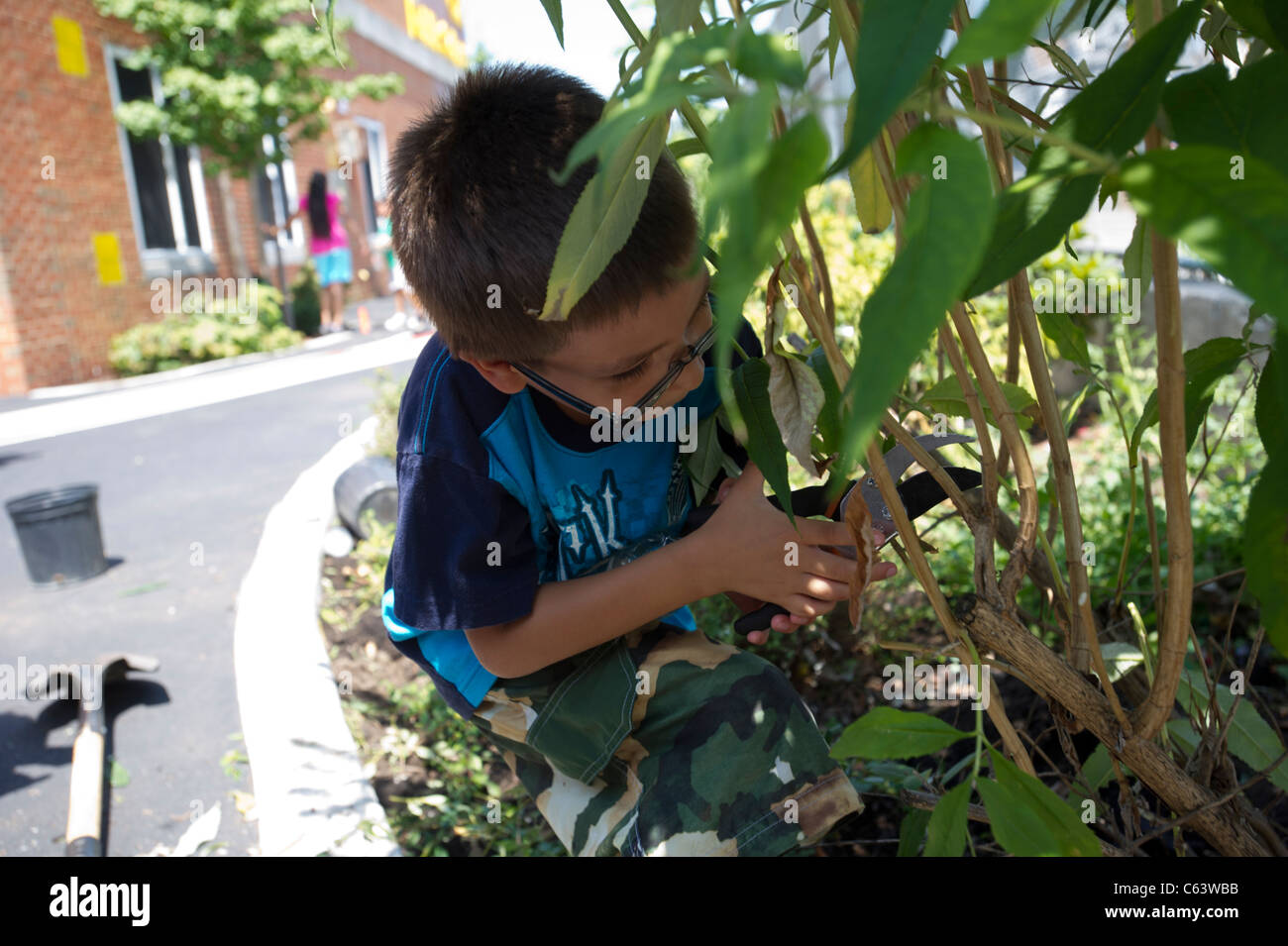 Gli studenti, la famiglia, gli amici e i volontari che partecipano in un giorno di lavoro in una scuola di New York Foto Stock