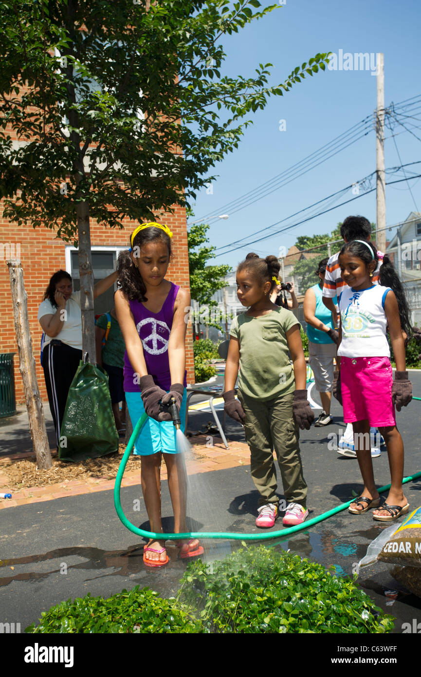 Gli studenti, la famiglia, gli amici e i volontari che partecipano in un giorno di lavoro in una scuola di New York Foto Stock