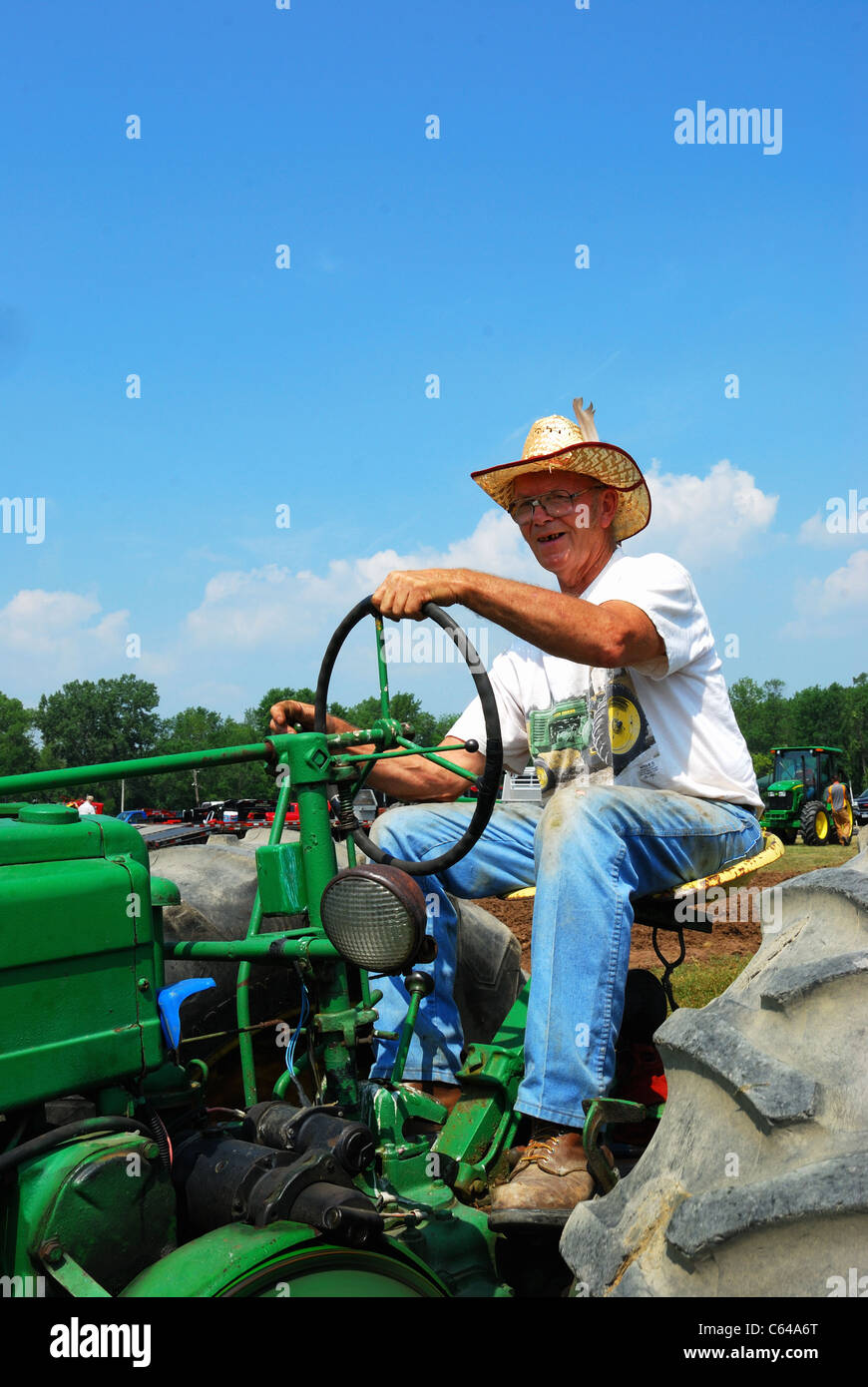 Vecchio contadino inizia il suo trattore in fiera Hemlock trattore tirare.. Foto Stock
