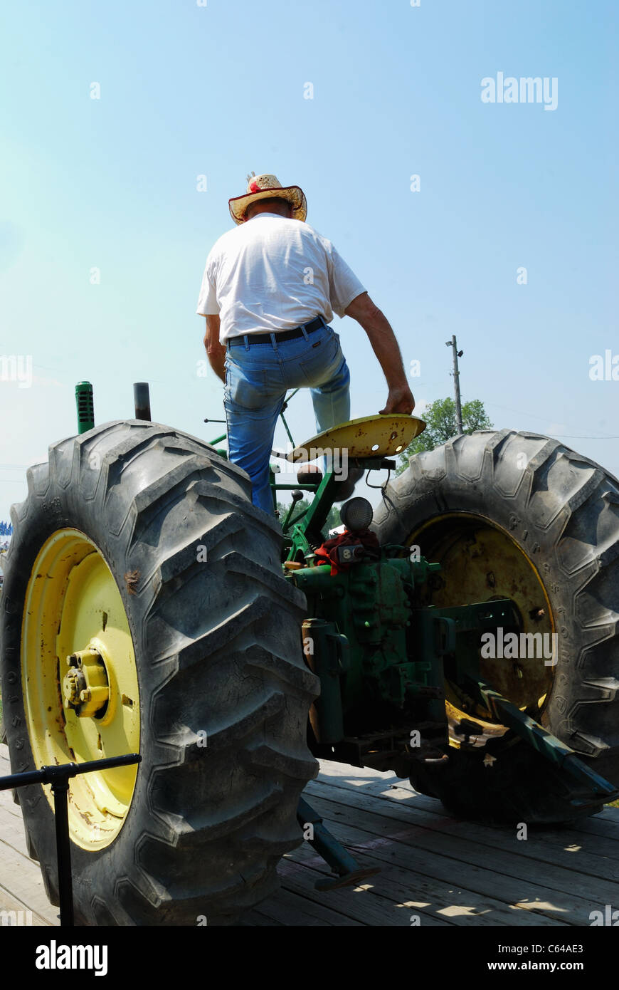 Trattore più vecchio con il senior contadino nel trattore tirare la concorrenza. Foto Stock