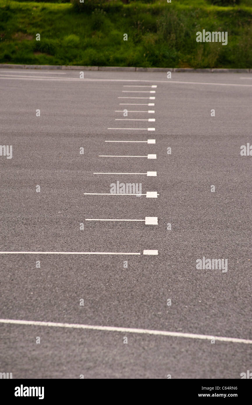 Dipinto di bianco che mostra le linee di aree di parcheggio in un vuoto di parcheggio auto Foto Stock