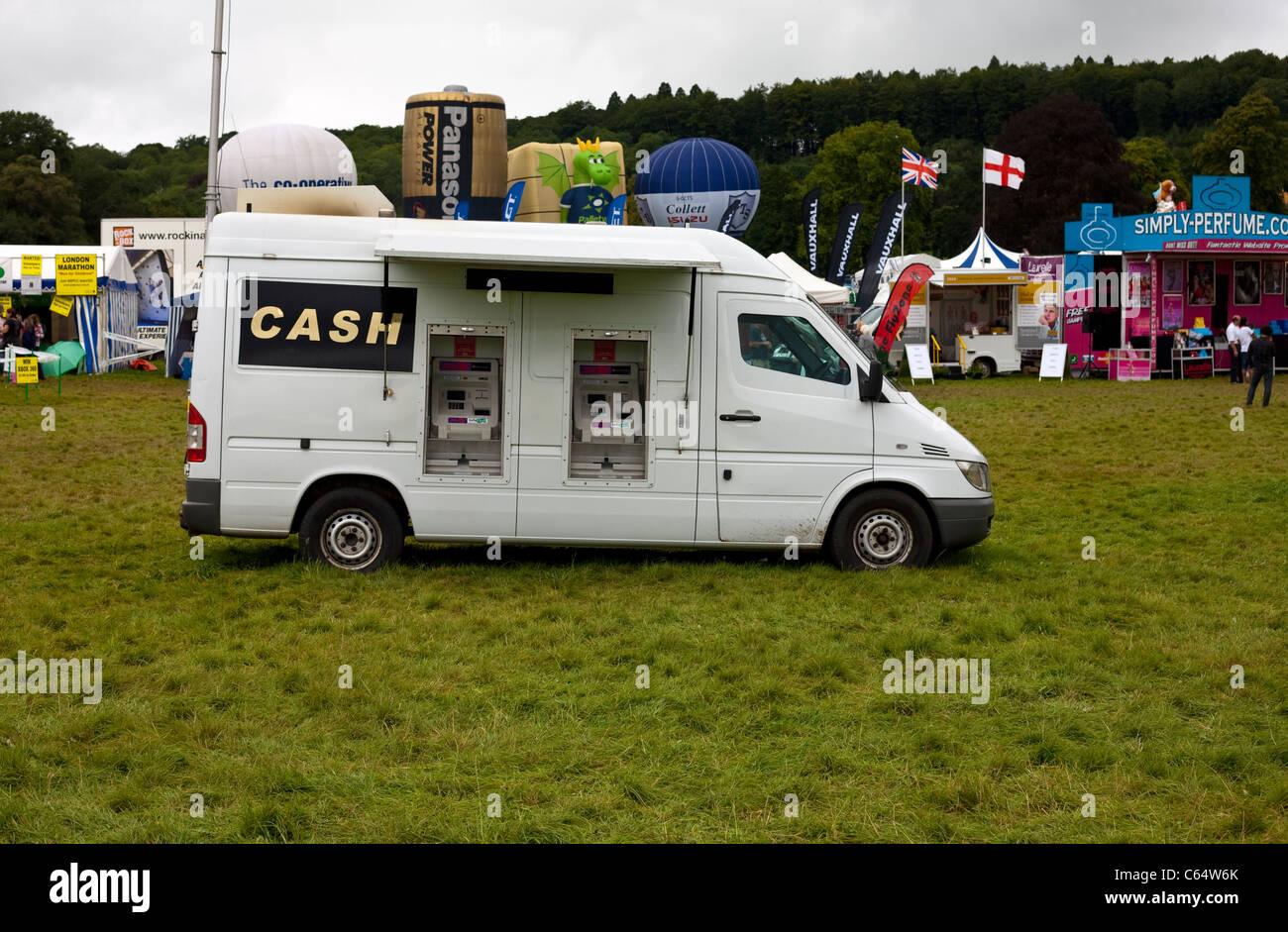 Mobile di cash dispenser sull'erba al Bristol Balloon Fiesta con palloncini e bancarelle dietro Foto Stock