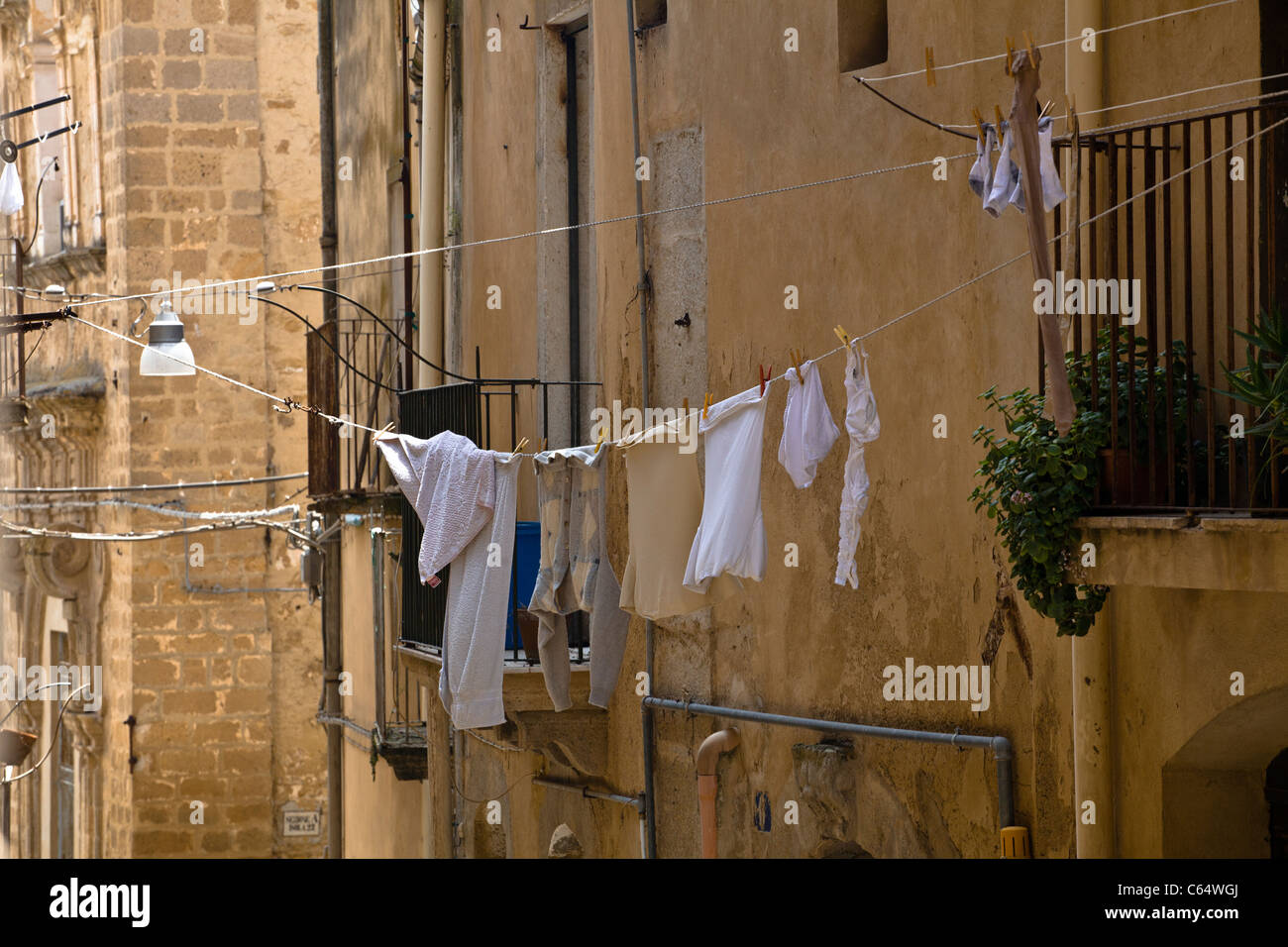 Tradizionale antica casa anteriore in Sicilia con biancheria di asciugatura (italiano di architettura medievale e barocca), Siracusa Italia, Europa Foto Stock