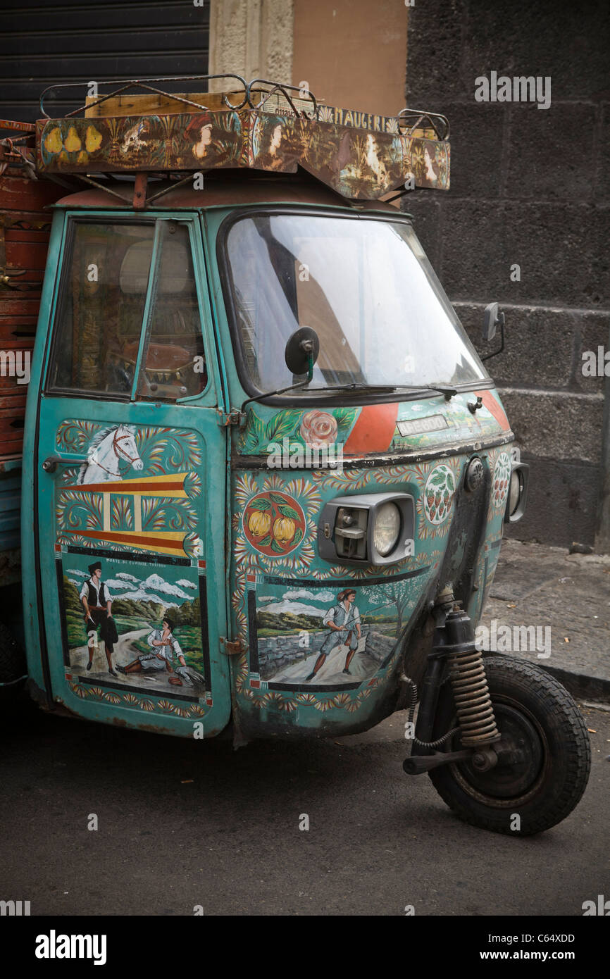 La pittura tradizionale su Vintage tre ruote ciclomotore Vespa parcheggiata vicino al mercato, Sicilia - Costa Mediterranea, Italia, Europa. Foto Stock