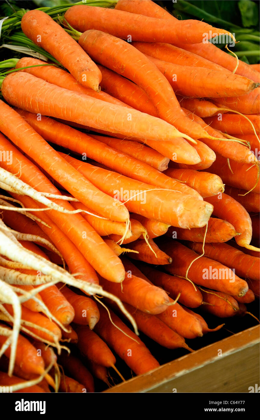 Cumulo di carote su un mercato, radice di prezzemolo sulla sinistra Foto Stock