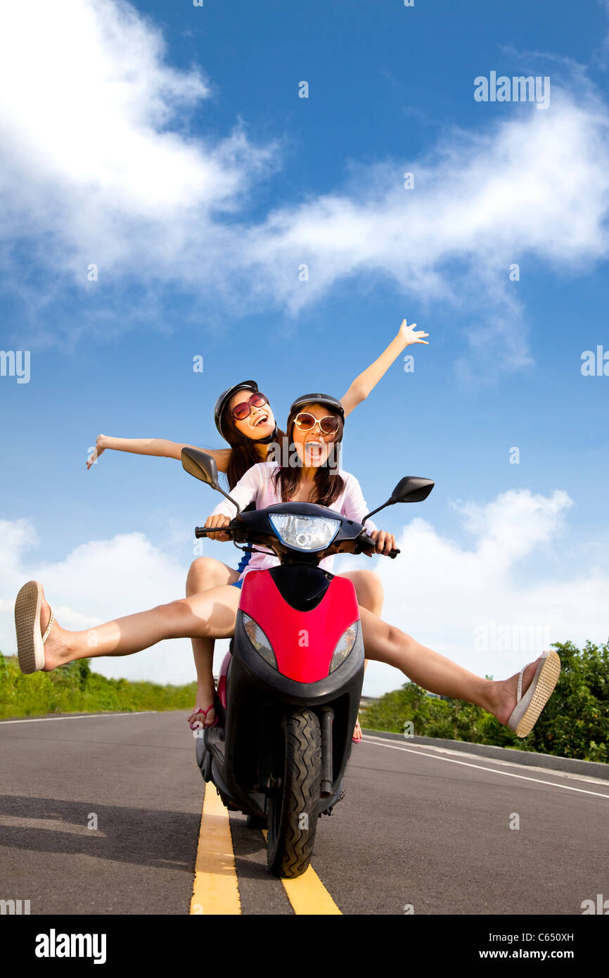Felice giovane donna avente estate viaggio su uno scooter Foto Stock
