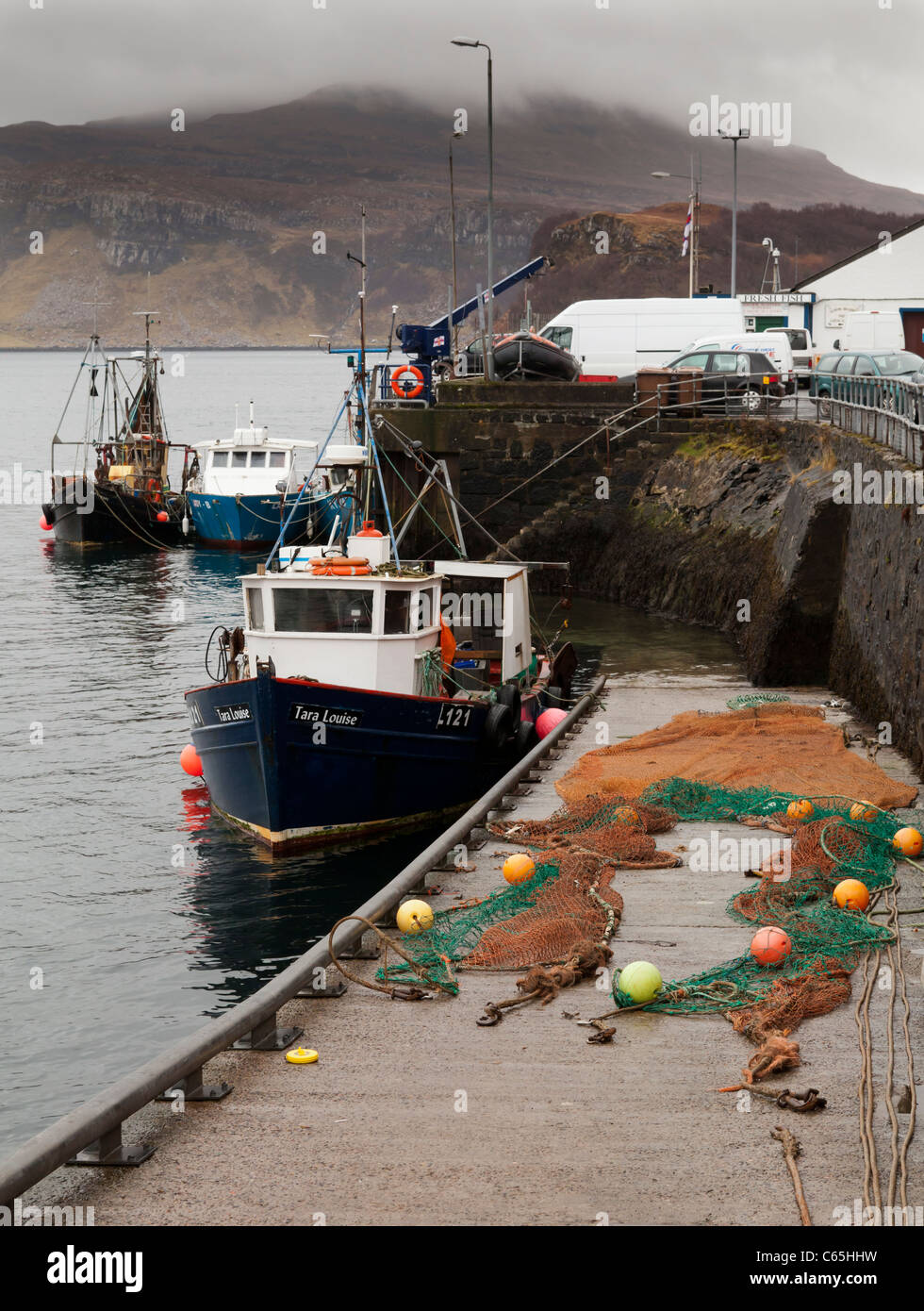 Barche da pesca e reti in porto, Portree, Isola di Skye in Scozia. Foto Stock