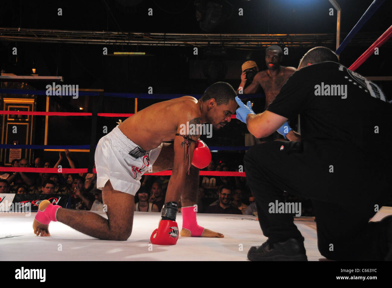 Marcus Fisher (bianco trunk) ottiene un conteggio di dieci re Opaku (nero trunk) ad una apparizione pubblica per prendere su mostra presenta $10.000 professionali Muay Thai Kick Boxing Tournament, 7 Treno Theatre, lavaggio, NY Luglio 17, 2010. Foto di: Gregorio T. Binuya/Everett Collection Foto Stock