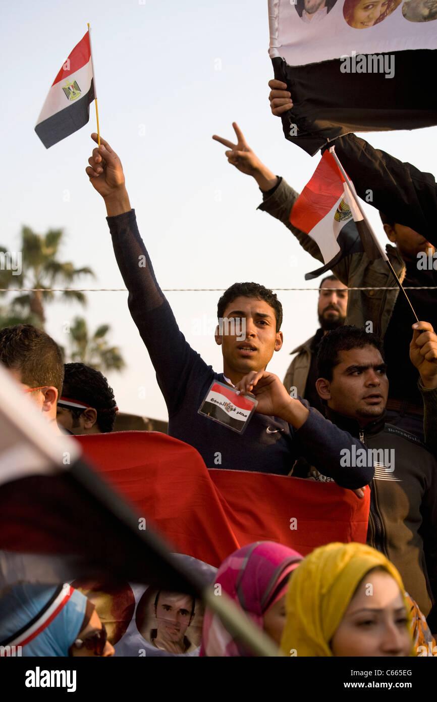 Un uomo onde una bandiera egiziana in piazza Tahrir ore prima il Presidente Mubarak passi verso il basso da ufficio su Feb.11, 2011 Foto Stock