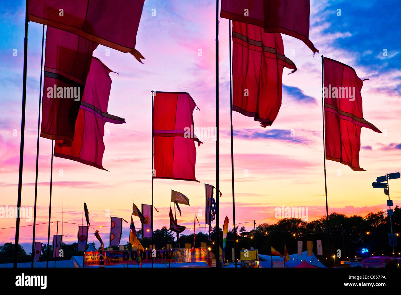 Festival bandiere contro un bel tramonto Cielo a WOMAD 2011, Charlton Park di Malmesbury, Wiltshire, Inghilterra, Regno Unito Foto Stock