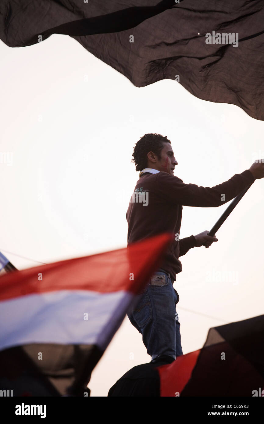 Su Feb.11, 2011 Un uomo sventola la bandiera egiziana al Cairo la piazza Tahrir ore prima il Presidente Mubarak passi verso il basso da office Foto Stock