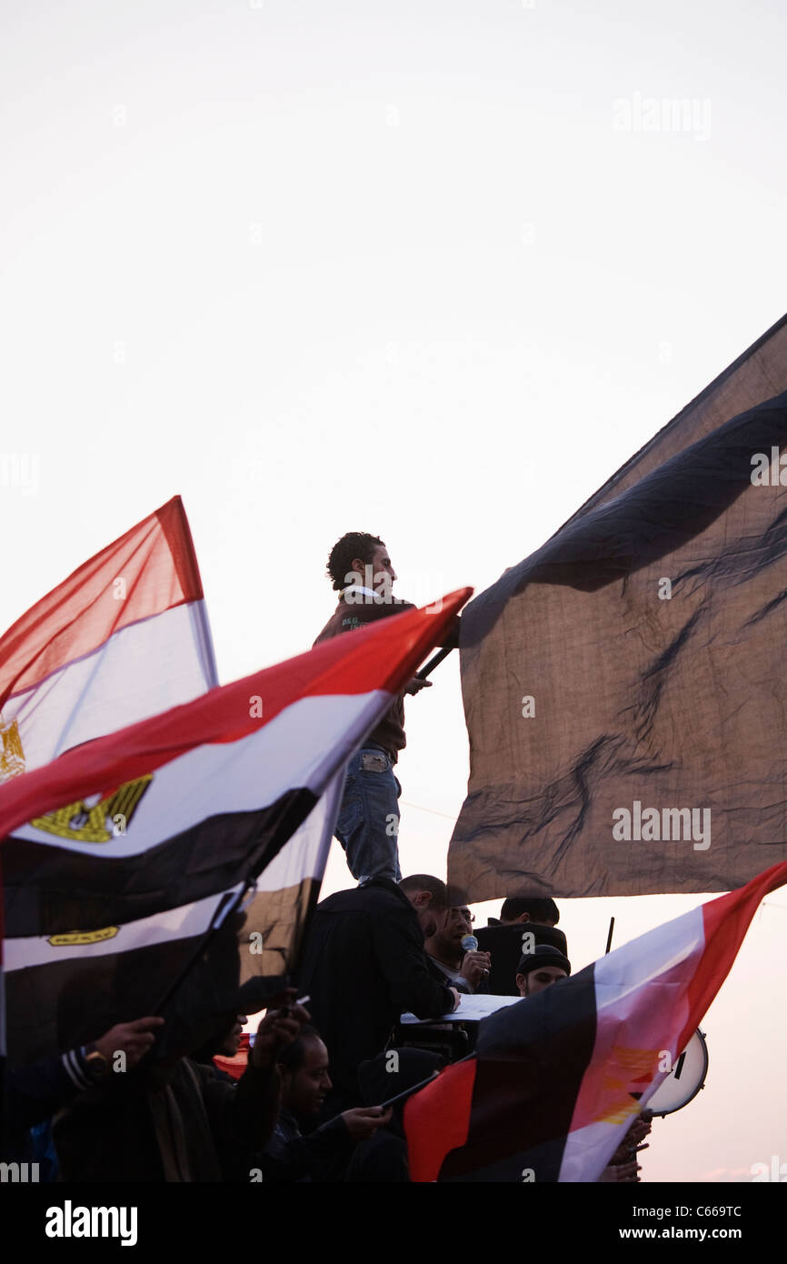 Su Feb.11, 2011 Un uomo sventola la bandiera egiziana al Cairo la piazza Tahrir ore prima il Presidente Mubarak passi verso il basso da office Foto Stock
