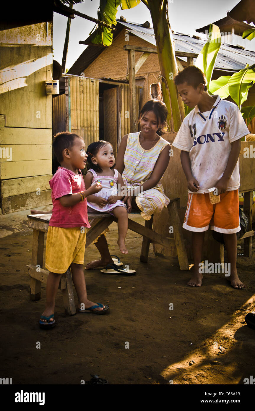 Donna balinese e bambini in run all area di Bali - ridere Foto Stock