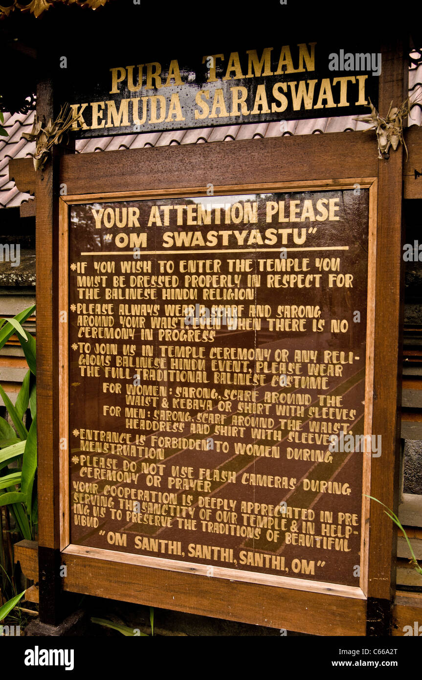 Insegna con le regole e il codice di abbigliamento all'esterno di un tempio di Bali. Foto Stock