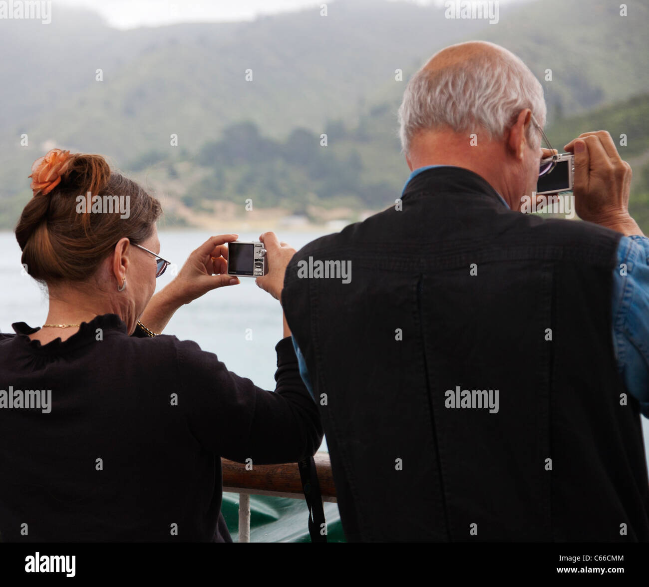 Una coppia matura, persone, scattare fotografie utilizzando fotocamere compatte. Foto Stock