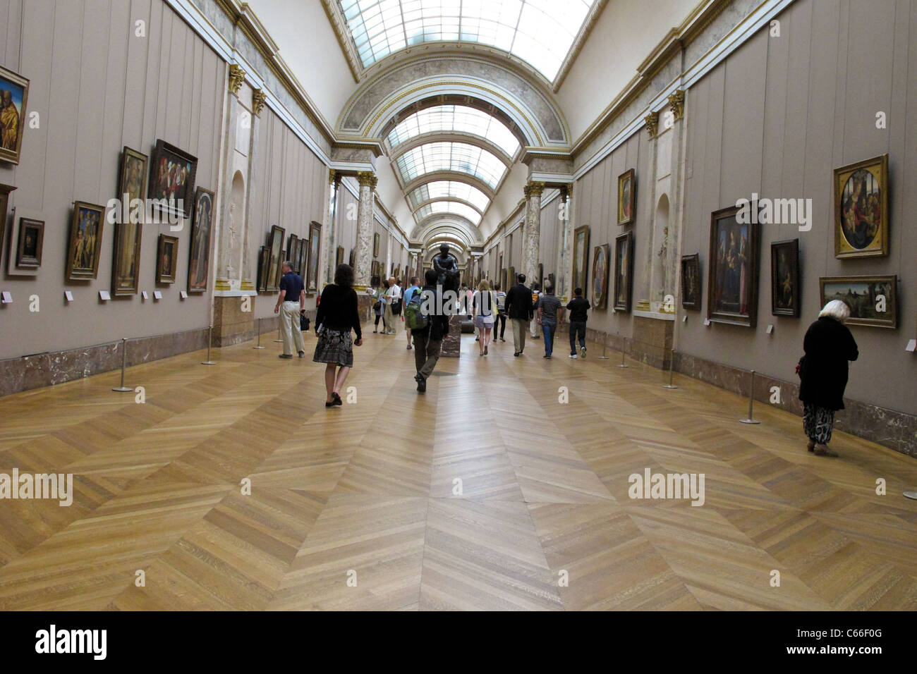 Ai visitatori di ammirare opere d'arte al museo del Louvre a Parigi Francia Foto Stock