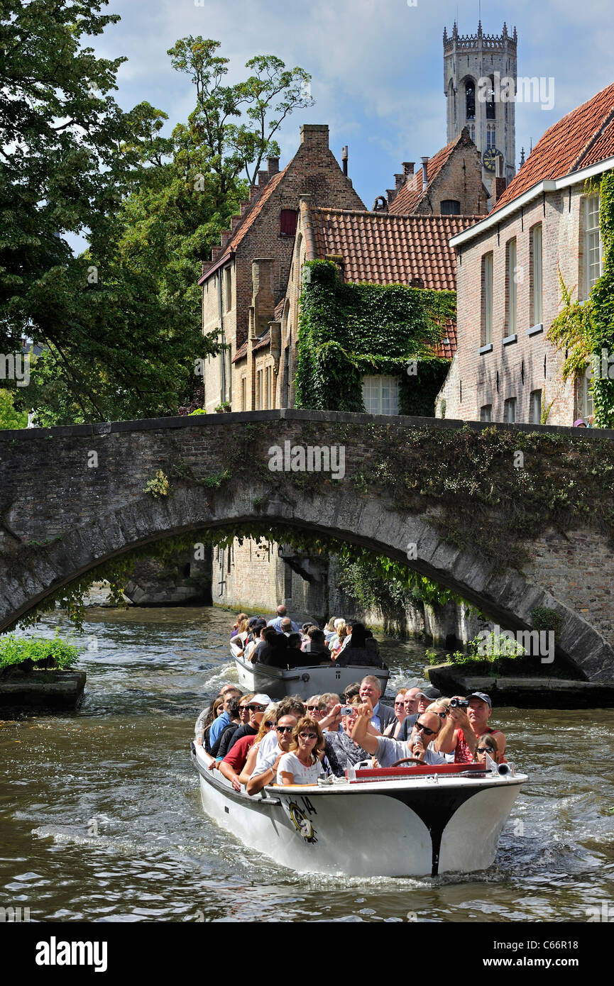 Belfry, il vecchio ponte sul canal e turisti durante la gita in barca lungo il Groenerei, Bruges, Belgio Foto Stock