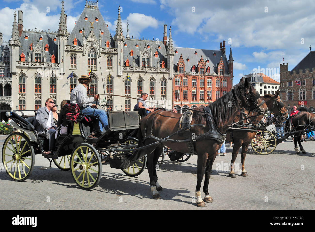 Corte Provinciale e turisti in carrozza trainata da cavalli per la gita turistica presso la piazza del Mercato / Grote Markt di Bruges, Belgio Foto Stock