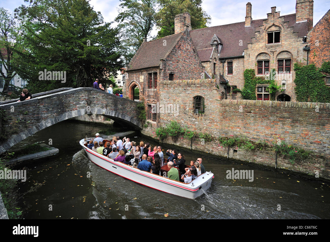 Bonifacius ponte sul canal e turisti durante la gita in barca a Bruges, Belgio Foto Stock