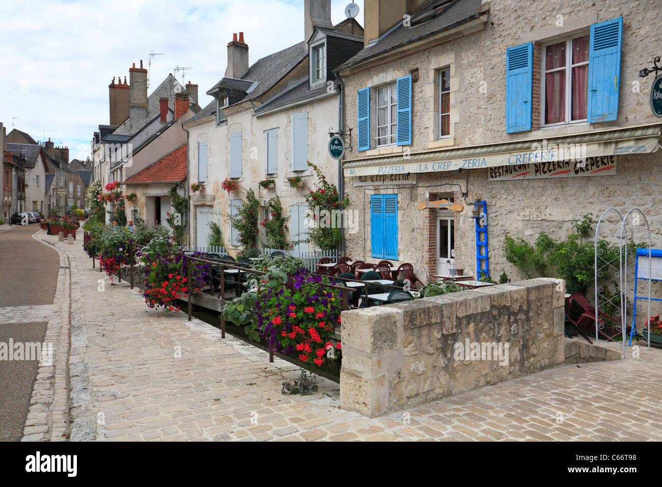 Flower rivestita Rue du Pont nel borgo medievale di Beaugency nella Valle della Loira, in Francia. Foto Stock