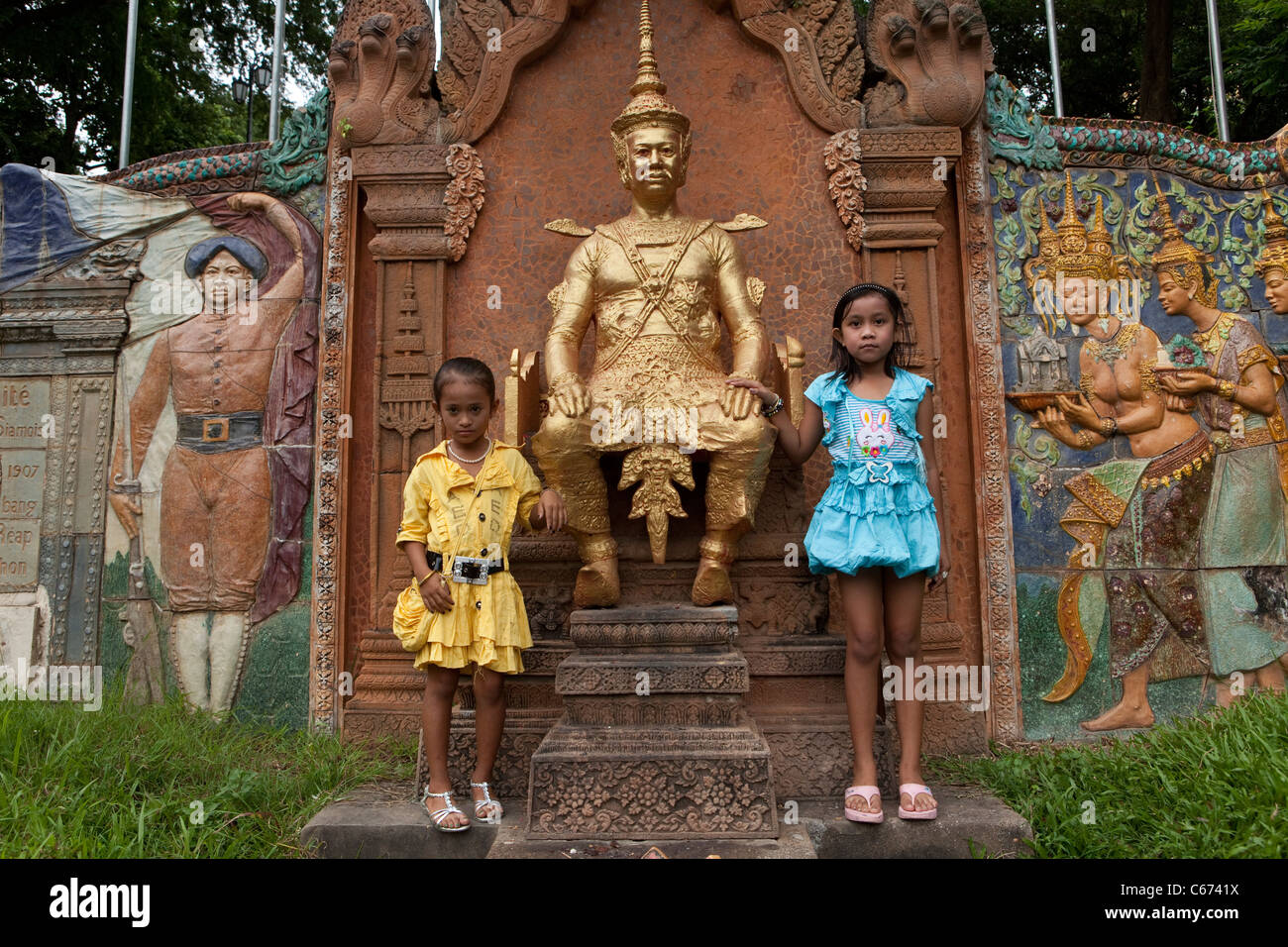 I bambini piccoli stand accanto alla statua in Phnom Penh Cambogia. Foto Stock