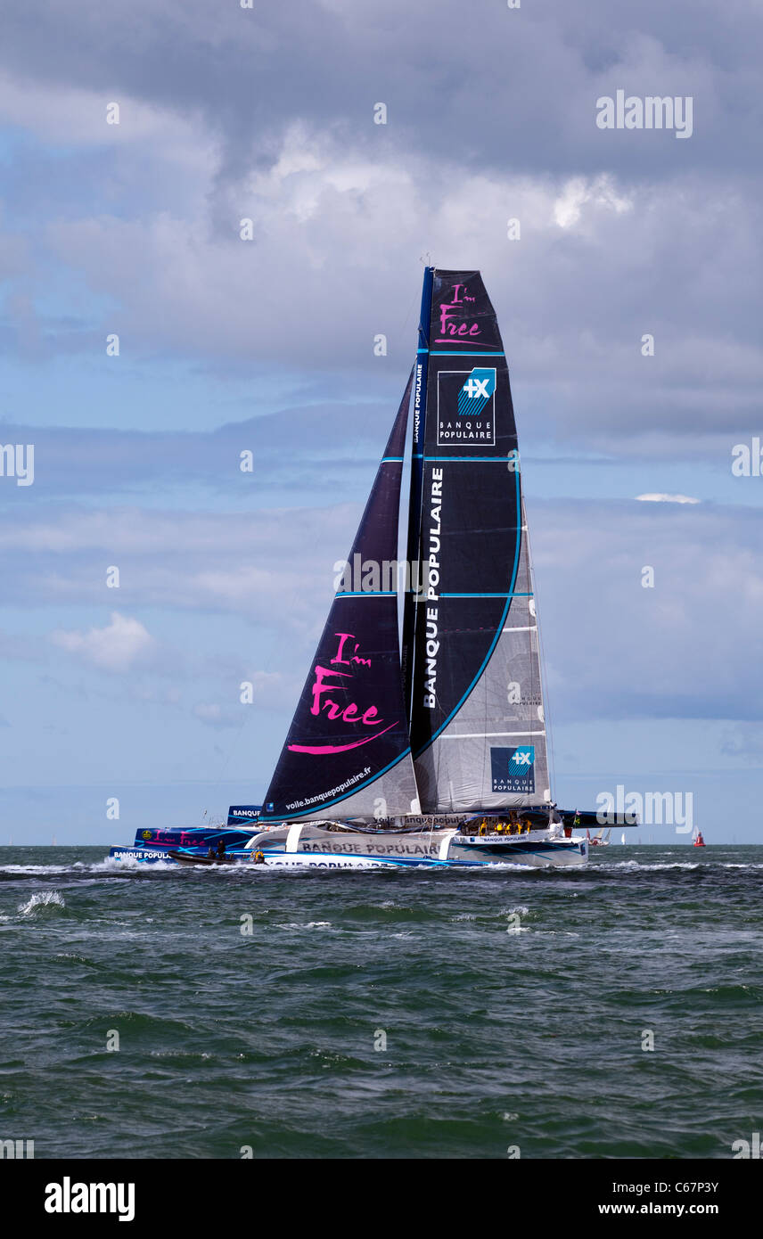 Maxi Banque Populaire V vela trimarano racing skipper da Loick Peyron high tech moderne prestazioni veloci in fibra di carbonio Fastnet Foto Stock