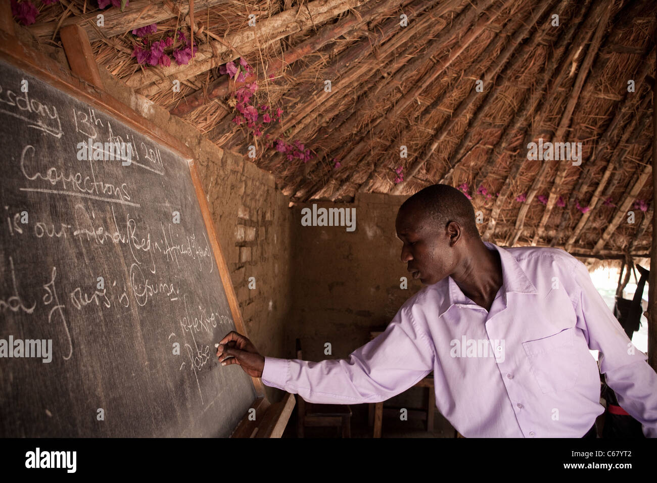 Una maestra insegna in un tetto di erba in aula Amuria, Uganda, Africa orientale. Foto Stock