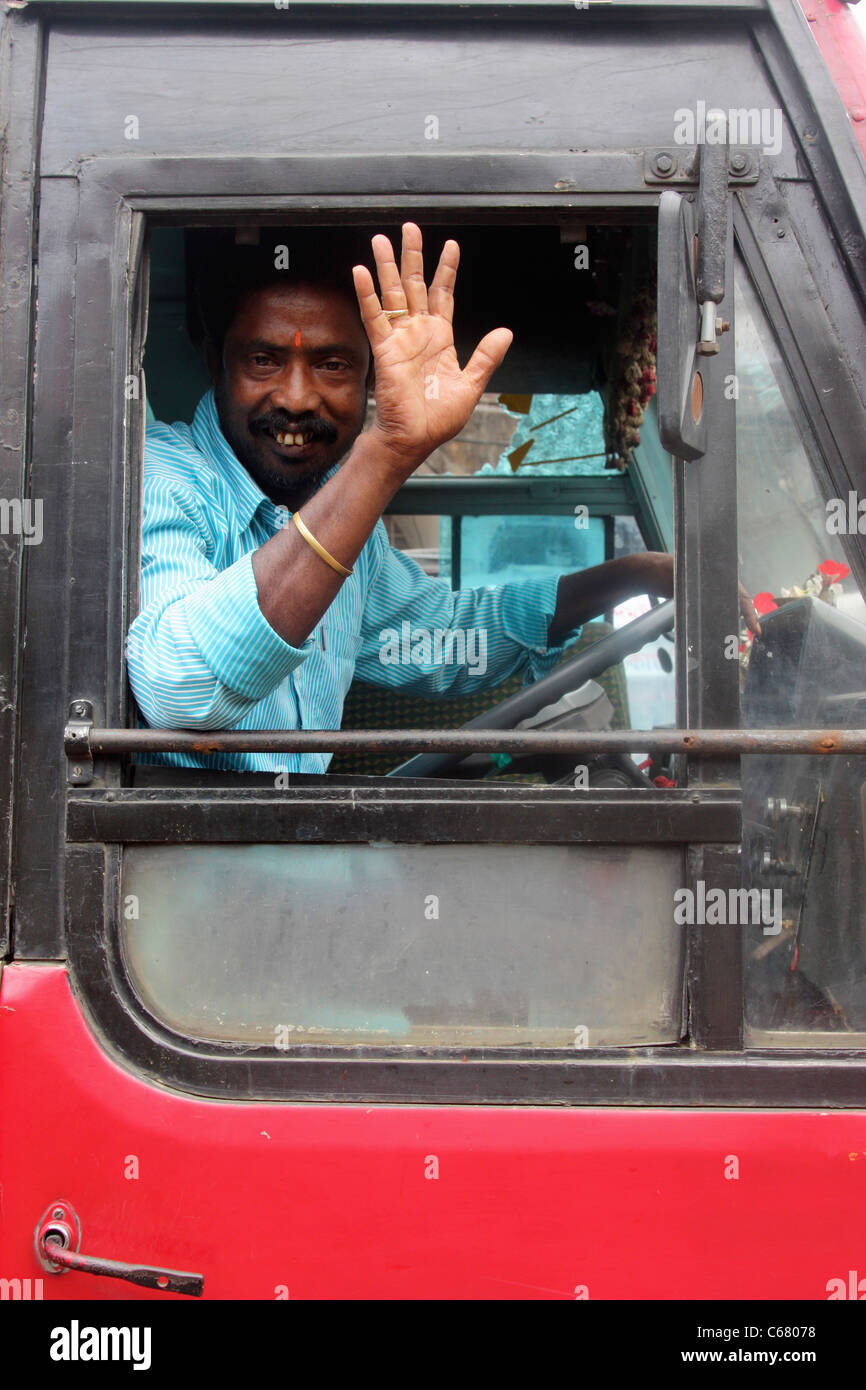 Driver di Asam bus di stato onde dal suo taxi Assam India Foto Stock