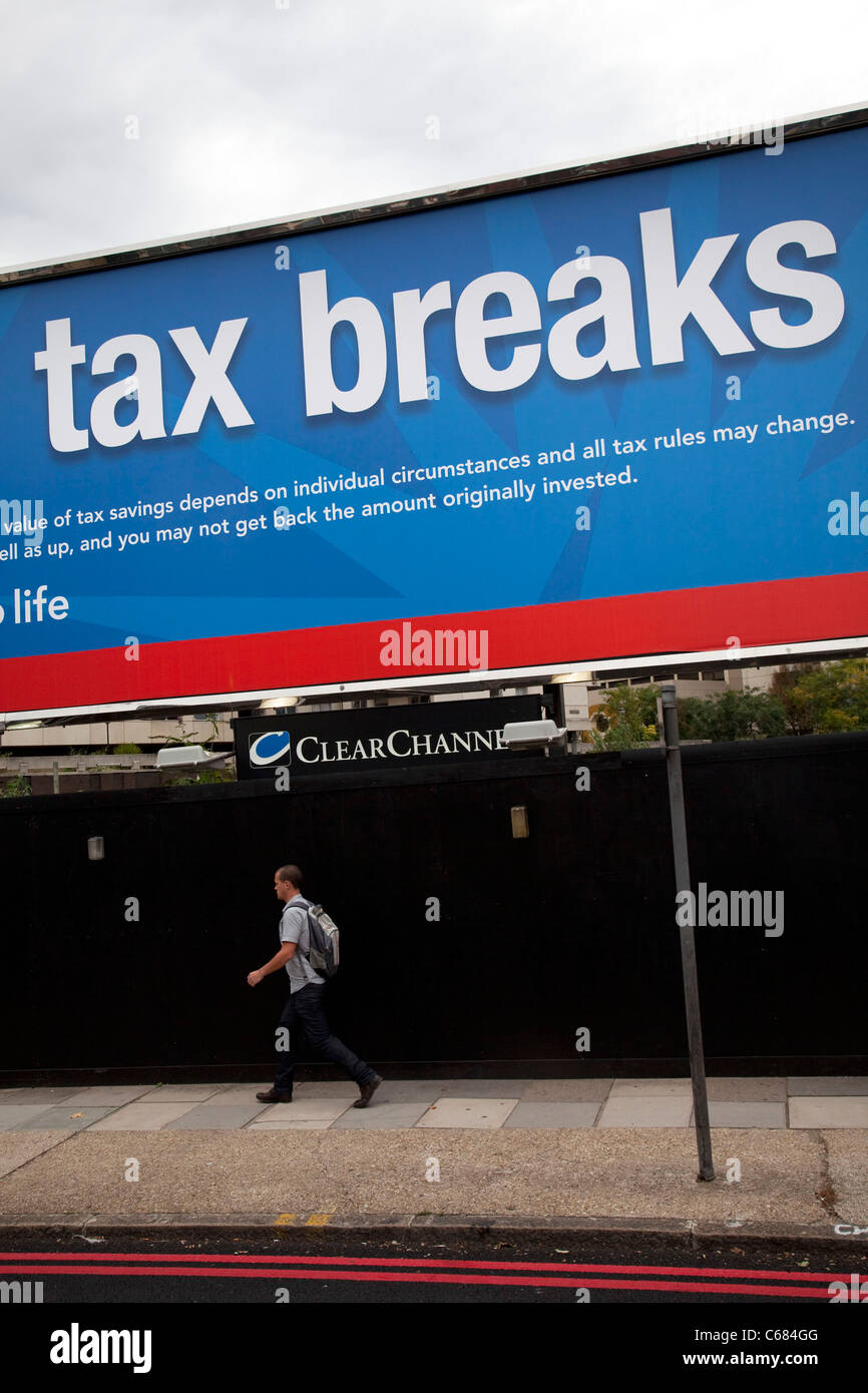 L'uomo cammina davanti ad un cartellone pubblicitario poster a Londra per chiedere di applicare sgravi fiscali ora. Regno Unito. Foto Stock