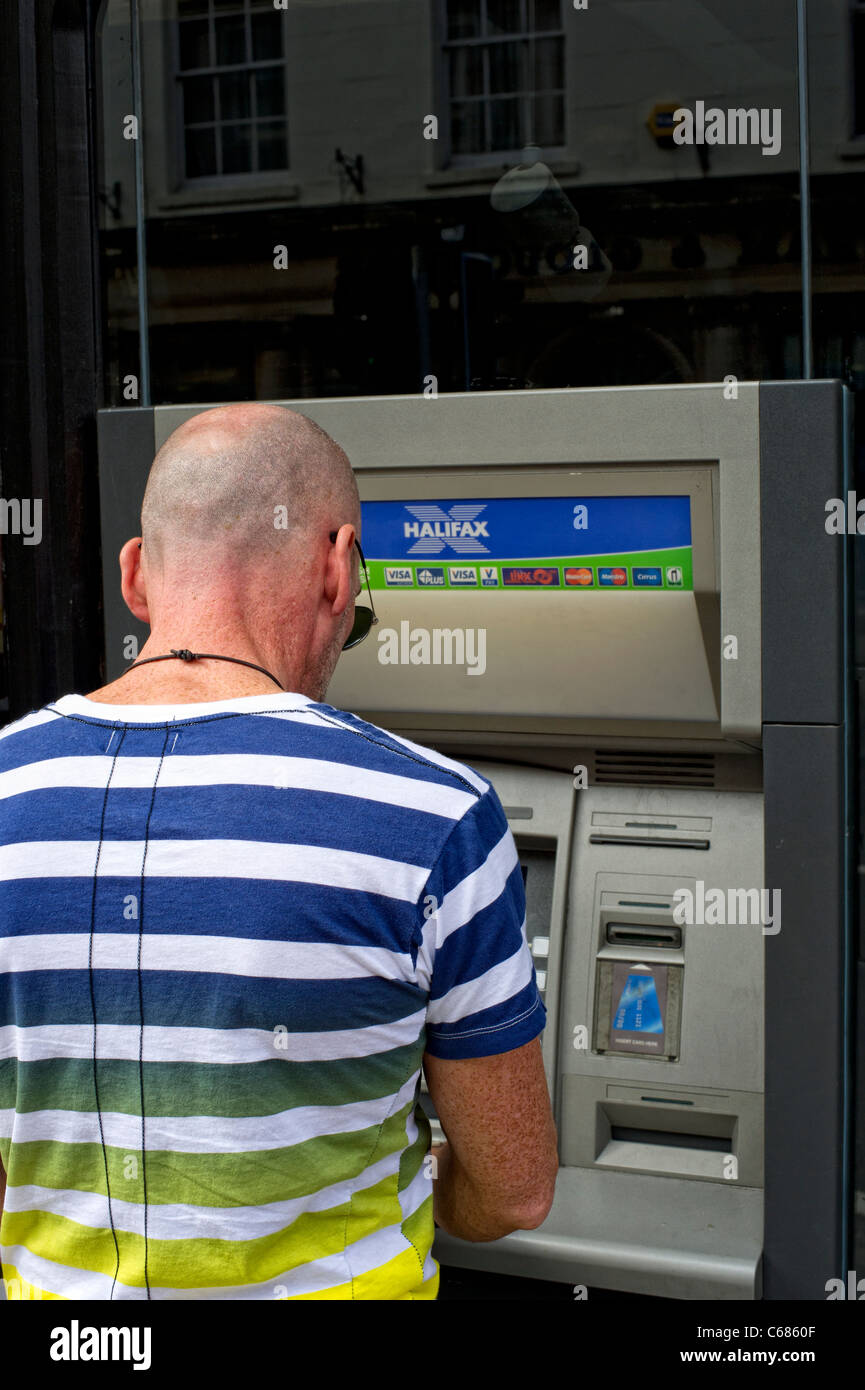 Uomo che utilizza Halifax (HBoS) cash dispenser Foto Stock