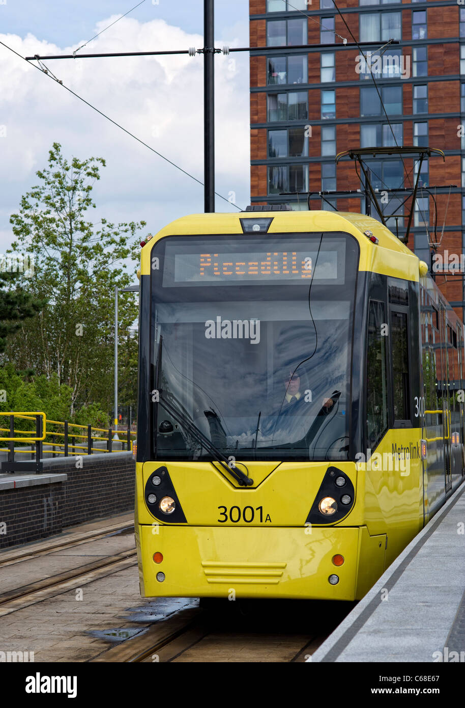 Uno dei moderni tram giallo in piedi in una piattaforma a MediaCityUK stazione in Salford Quays (parte della Metrolink system) Foto Stock