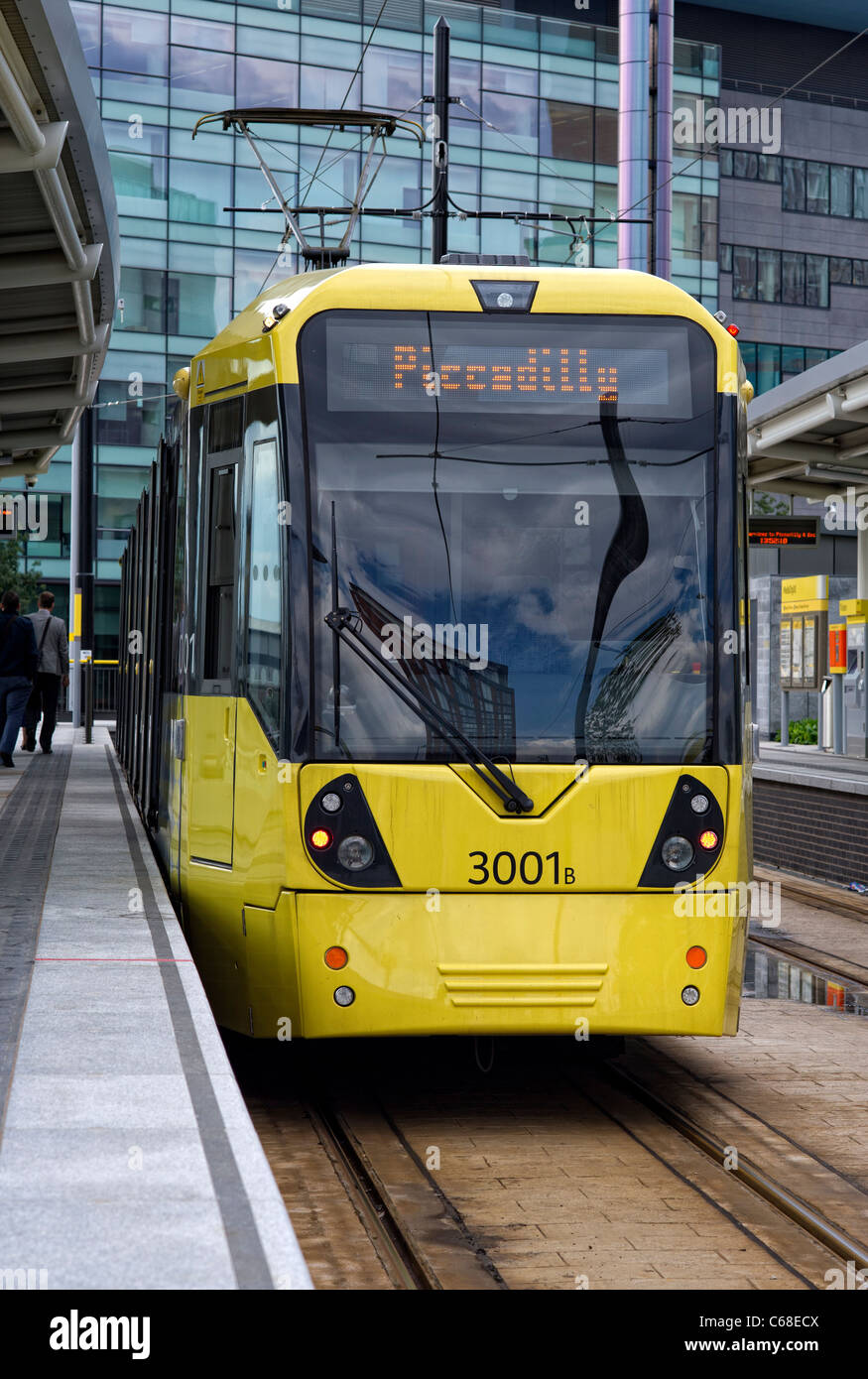 Uno dei moderni tram giallo in piedi in una piattaforma a MediaCityUK stazione in Salford Quays (parte della Metrolink system) Foto Stock