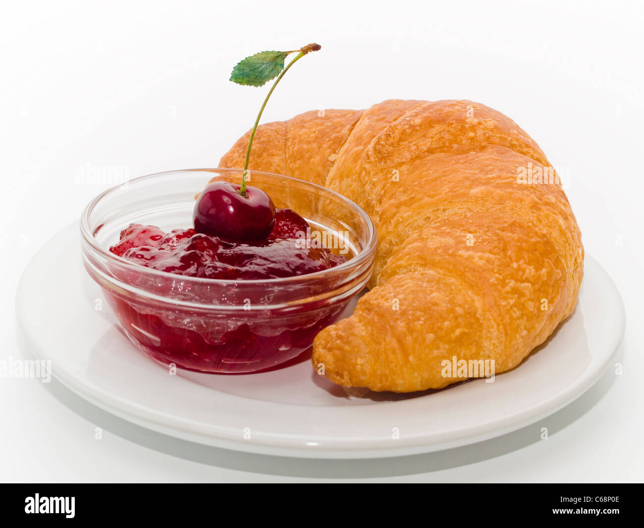 Ein Teller Mit einem Croissant und einem Schälchen Konfitüre | una piastra withe un cornetto e una piccola ciotola di inceppamento Foto Stock