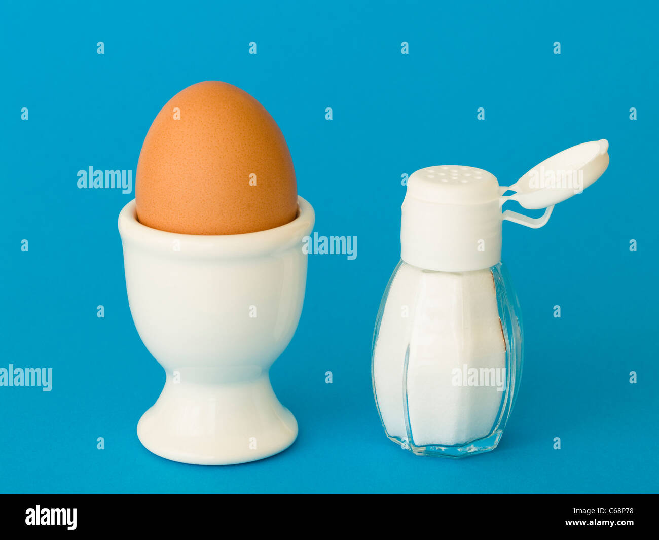 Uno eggcup con un marrone di un uovo di gallina, accanto è un saltcellar Foto Stock