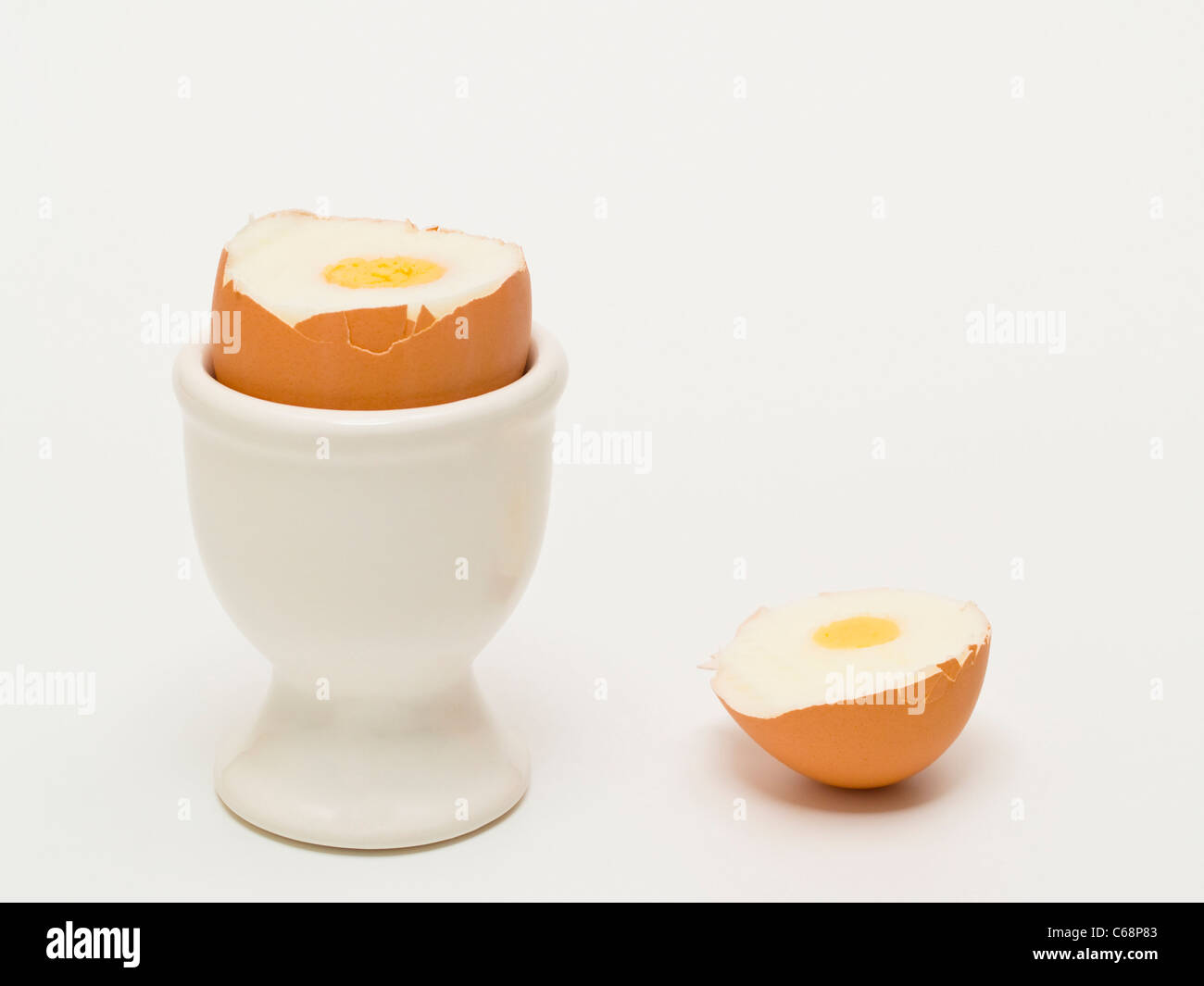 Ein geköpftes Hühnerei steht im Eierbecher | uno decapitato di un uovo di gallina in un eggcup Foto Stock