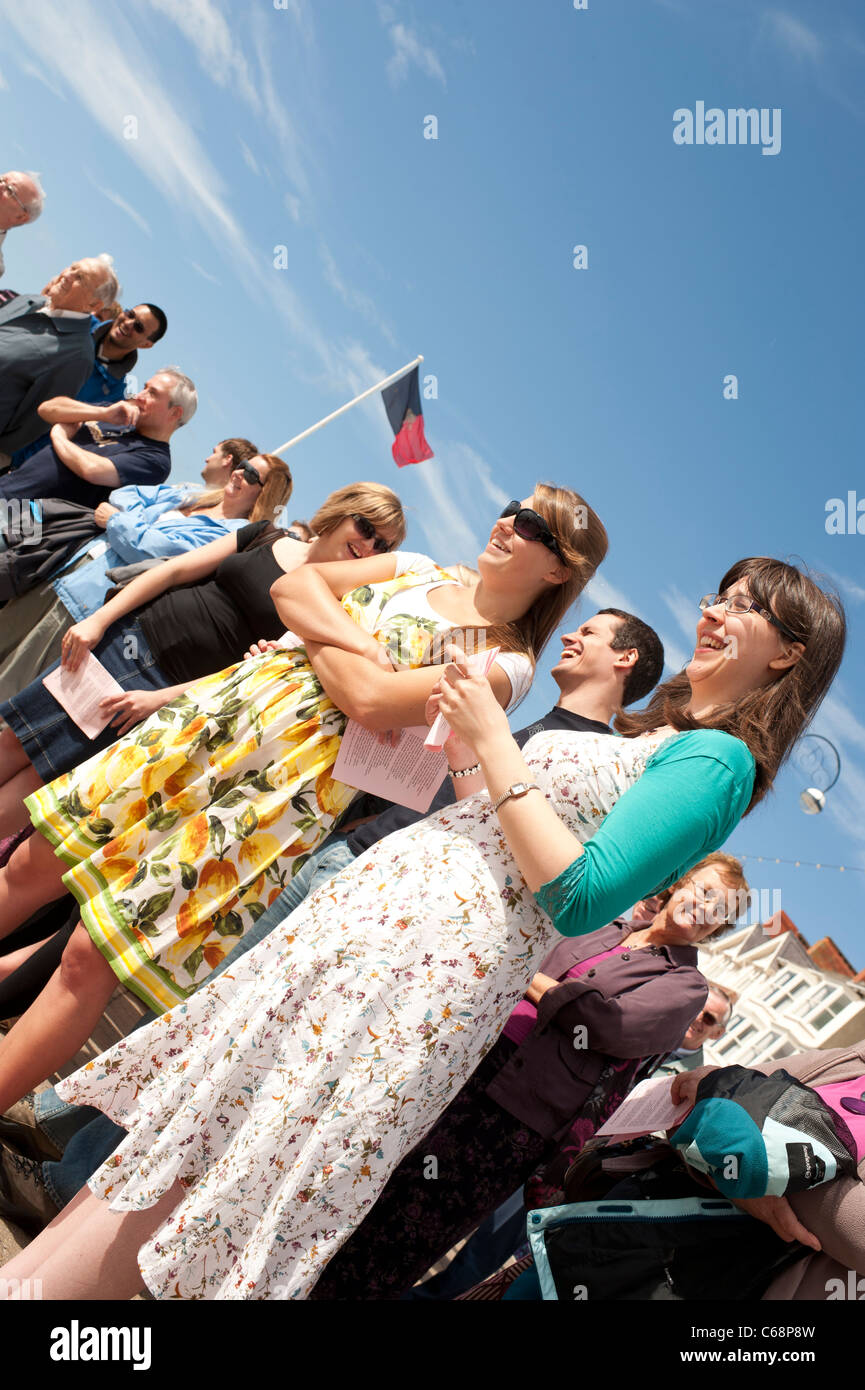Giovani donne che cantano in una cristiana evangelica all'aperto Servizio di culto sul lungomare a Aberystwyth Wales UK Foto Stock