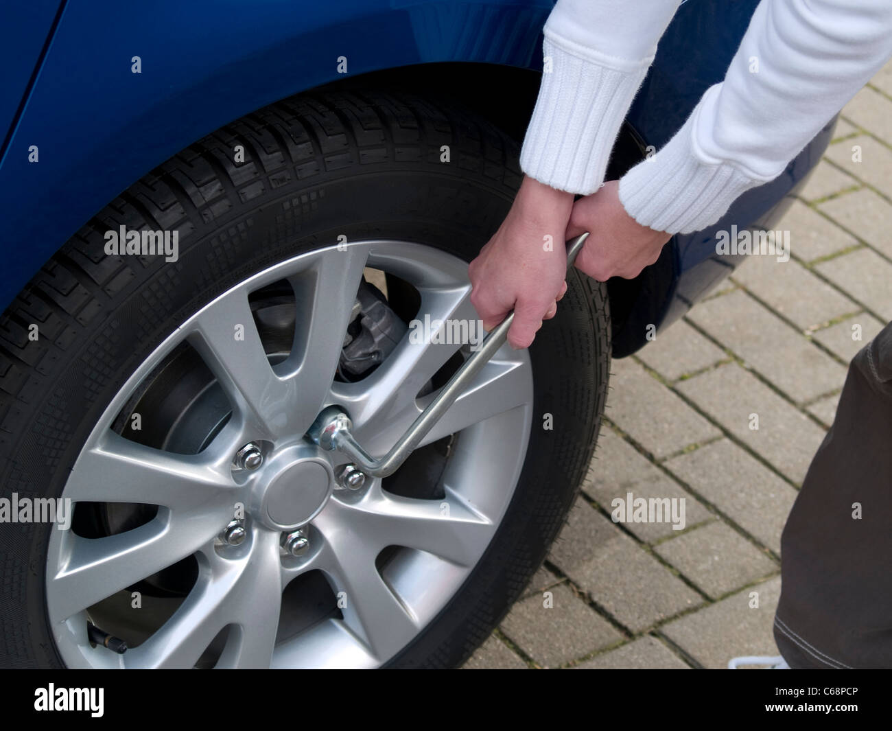 Detailansicht einer persona beim Radwechsel am Auto | vista in dettaglio di una persona al volante cambia in auto Foto Stock