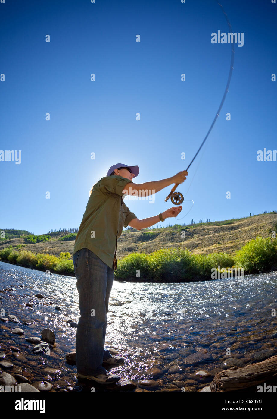 La donna la colata di una fly canna da pesca Foto Stock