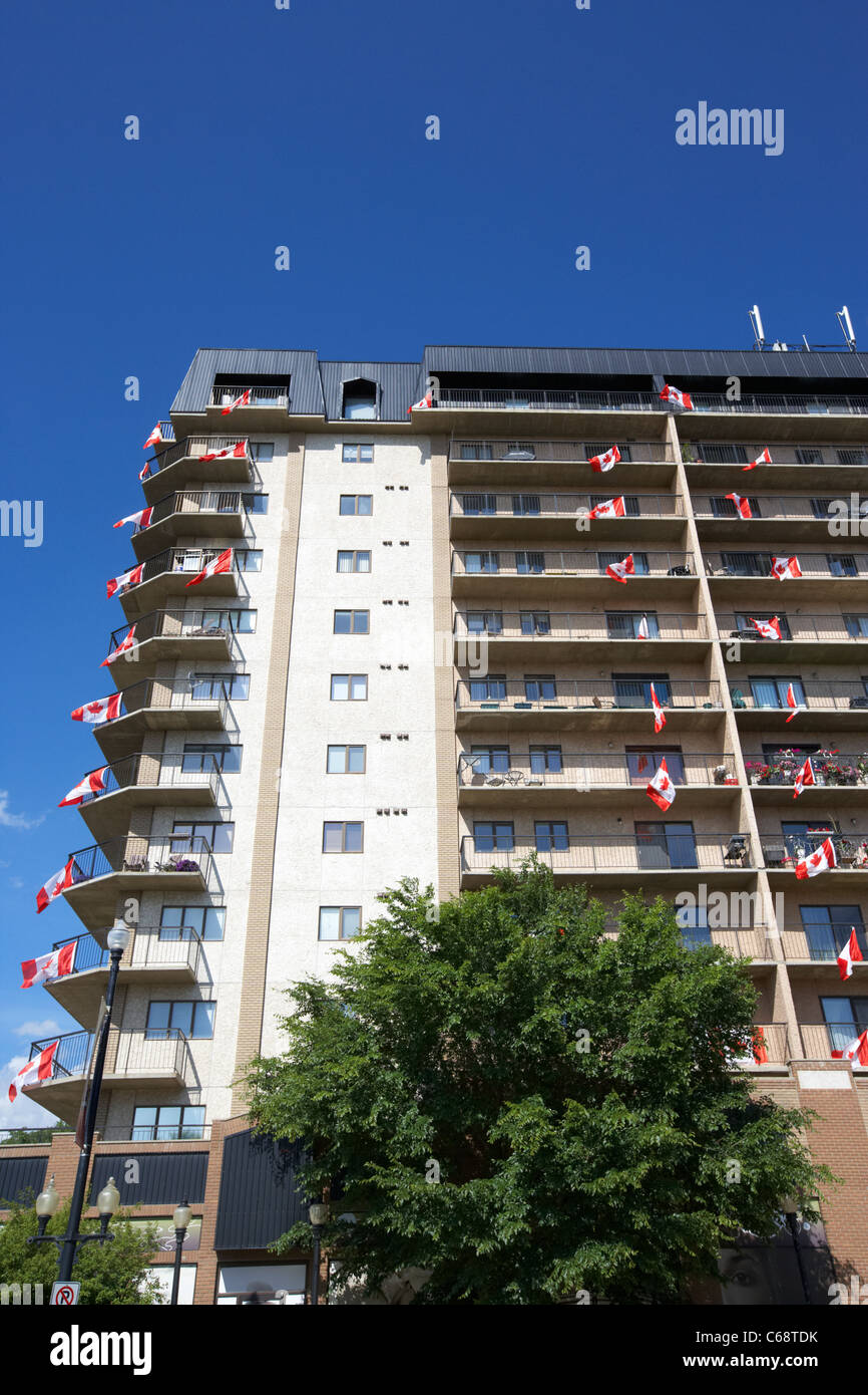 Tower Apartment Block con appartamenti battenti bandiere canadesi per il Canada giorno Saskatoon Saskatchewan Canada Foto Stock